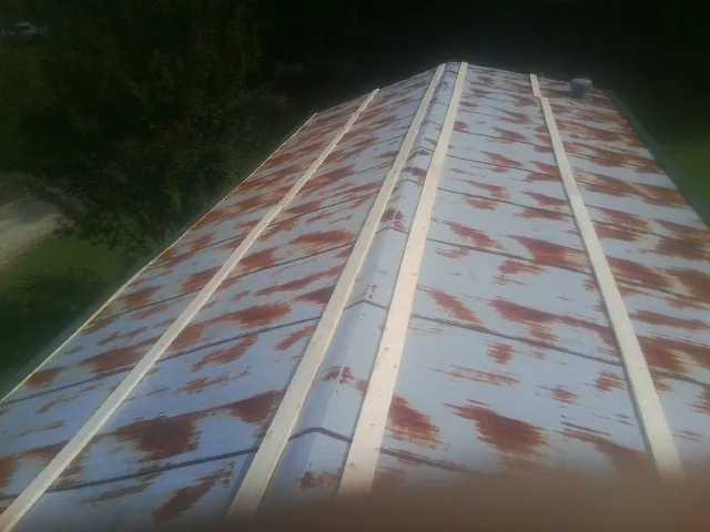 Rusted metal roof panels with new wood purlins before replacement — Storm Damage Roof Repair in Peabody by Roofing Brothers
