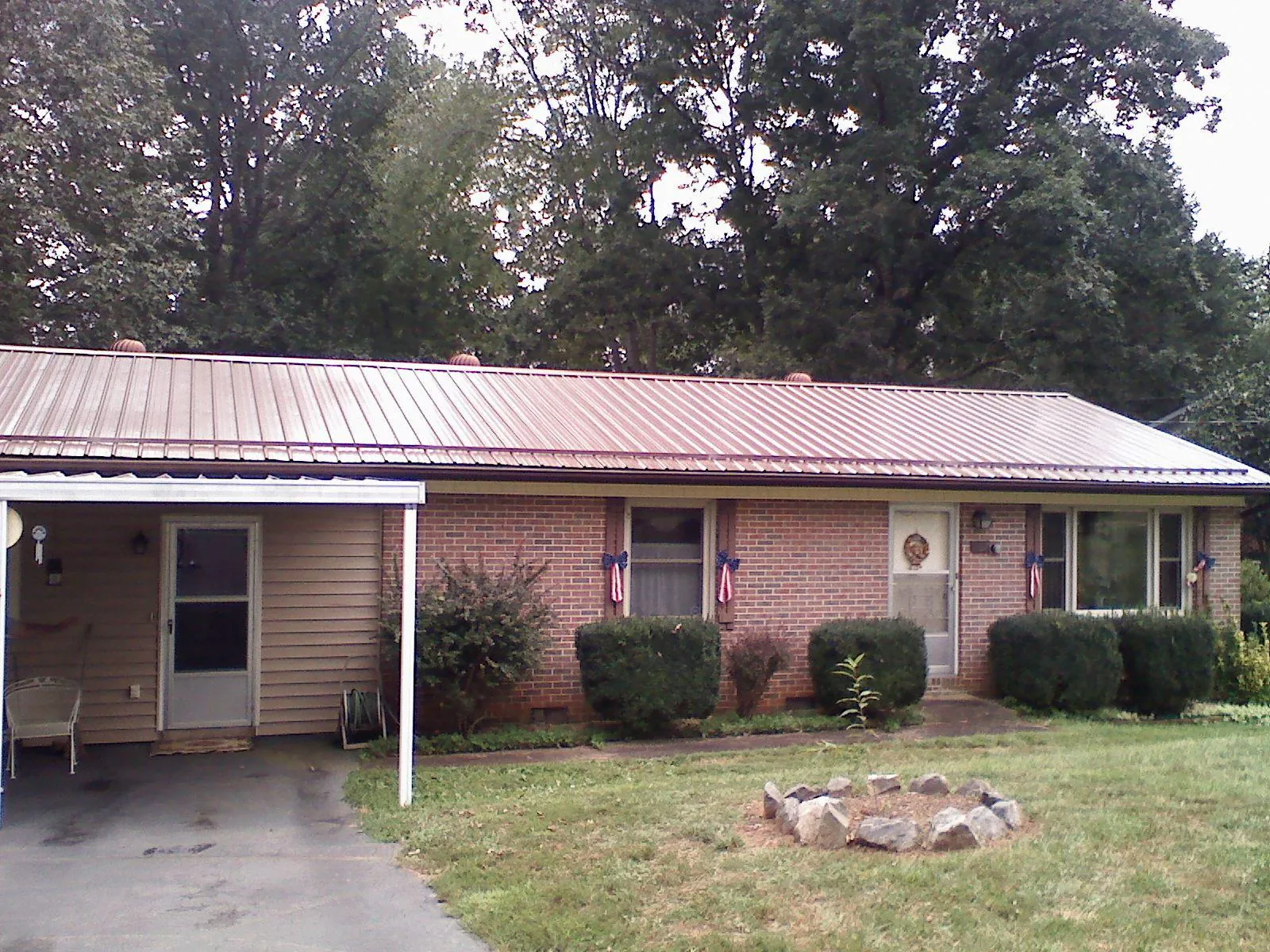 Bronze metal roof and carport on a brick ranch home — Roof Repair work by our crew in Peabody